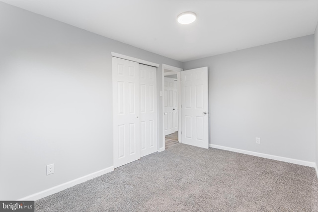 unfurnished bedroom with carpet flooring and a closet