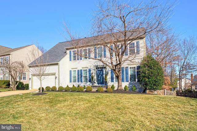 colonial inspired home featuring a garage and a front yard