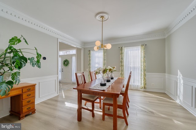 dining space featuring an inviting chandelier, crown molding, and light hardwood / wood-style floors