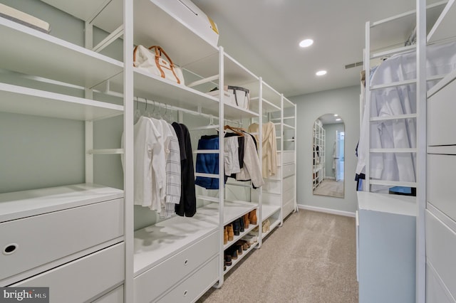 walk in closet featuring light colored carpet