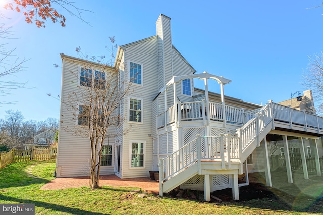 back of property featuring a lawn, a patio, and a deck