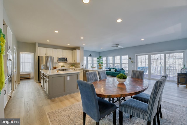 dining room with ceiling fan and light hardwood / wood-style flooring