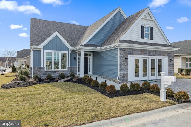 craftsman-style home featuring french doors and a front yard