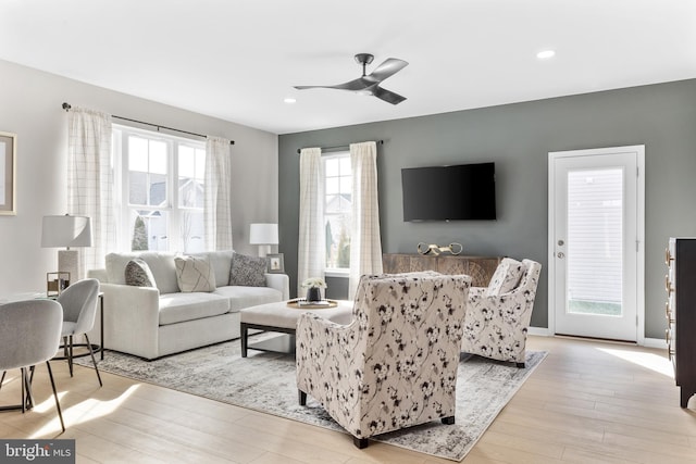 living room featuring light hardwood / wood-style flooring and ceiling fan