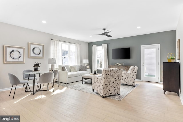 living room with light hardwood / wood-style flooring and ceiling fan