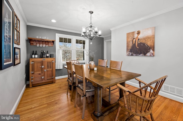 dining room featuring light wood-type flooring, baseboards, and crown molding