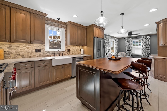 kitchen featuring backsplash, plenty of natural light, appliances with stainless steel finishes, and a sink