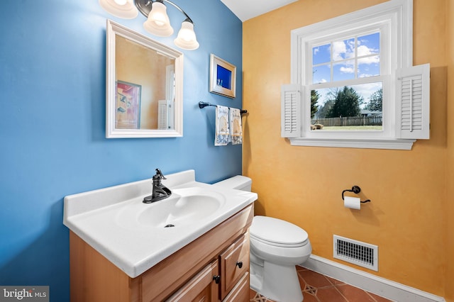 half bath with tile patterned floors, visible vents, toilet, and vanity