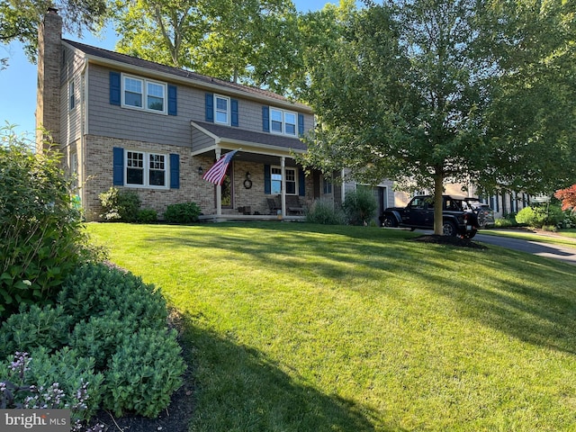 view of front of home with a front lawn, a porch, a garage, brick siding, and a chimney