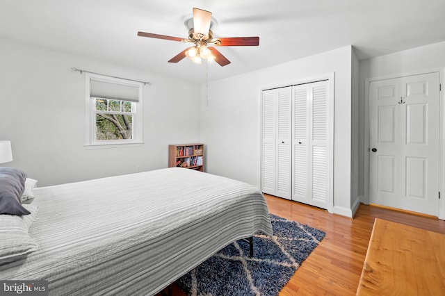 bedroom featuring a closet, baseboards, ceiling fan, and light wood finished floors