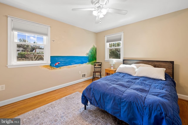 bedroom featuring visible vents, wood finished floors, baseboards, and ceiling fan