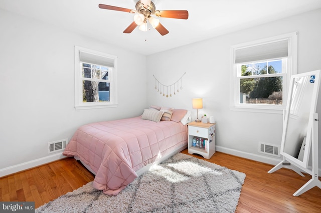 bedroom featuring multiple windows, light wood-style floors, and visible vents