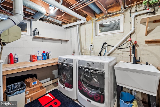 laundry area with a sink, laundry area, and washer and clothes dryer