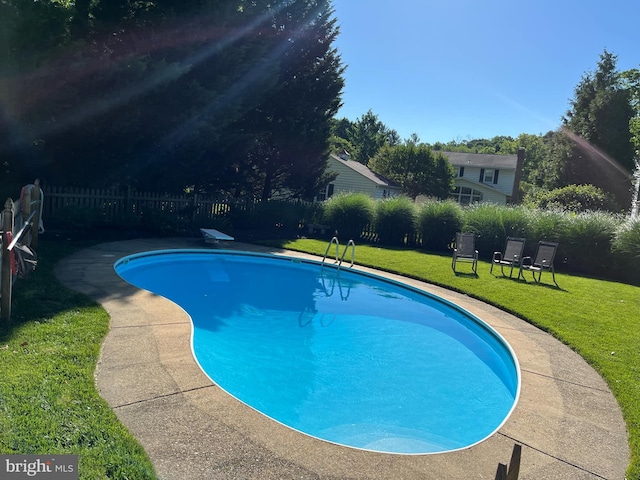 view of swimming pool with a lawn, fence, and a fenced in pool