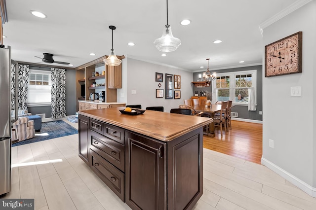 kitchen with recessed lighting, ceiling fan with notable chandelier, light countertops, and ornamental molding