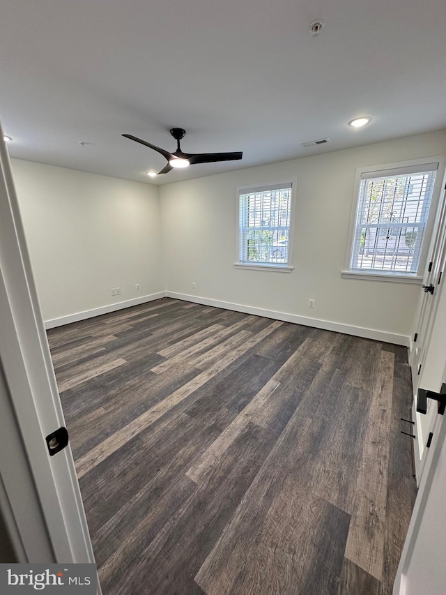 spare room with ceiling fan, a healthy amount of sunlight, and dark hardwood / wood-style floors