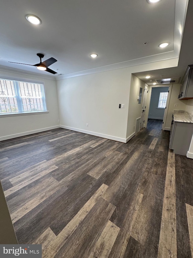 unfurnished living room with ornamental molding, dark wood-type flooring, and ceiling fan