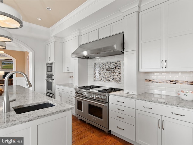 kitchen with sink, white cabinets, stainless steel appliances, crown molding, and light stone countertops