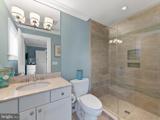 bathroom featuring crown molding, vanity, toilet, and a shower with shower door