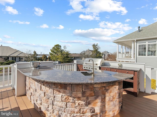 deck featuring area for grilling, an outdoor bar, and exterior kitchen