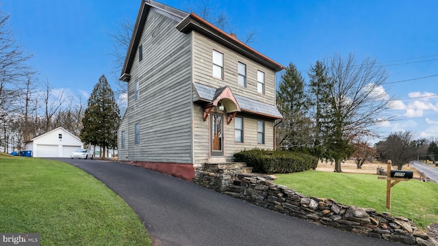 view of front of house with an outbuilding, a garage, and a front yard