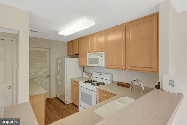 kitchen featuring white appliances, visible vents, light countertops, and light brown cabinetry