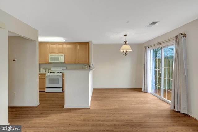 kitchen featuring white appliances, visible vents, light wood-style floors, light countertops, and pendant lighting