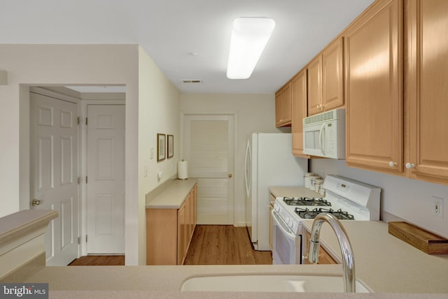 kitchen with white appliances, visible vents, light countertops, and light brown cabinetry