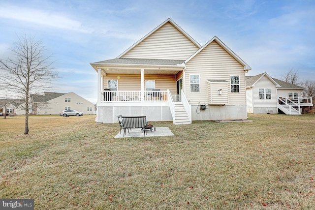 rear view of property featuring a porch, a patio, and a lawn