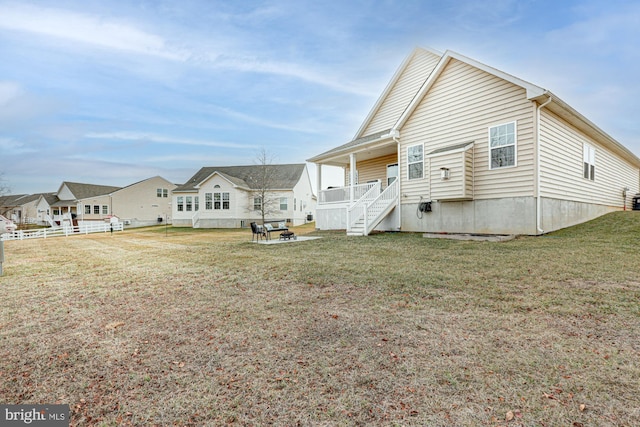 rear view of house featuring a yard