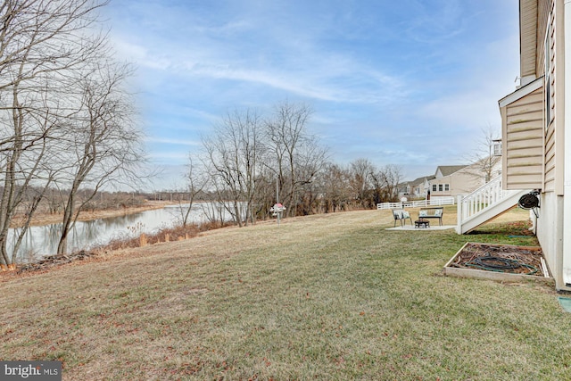 view of yard featuring a water view and a patio