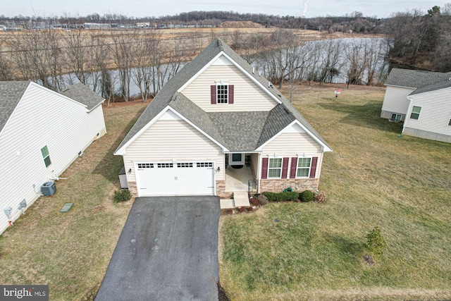 view of front of house with a garage, a front yard, covered porch, and central air condition unit