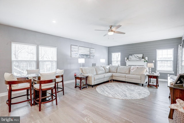 living room featuring ceiling fan and light hardwood / wood-style flooring