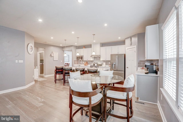 dining room featuring sink and light hardwood / wood-style floors