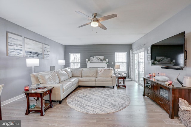 living room featuring ceiling fan, a wealth of natural light, and light wood-type flooring