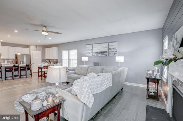 living room featuring ceiling fan and light hardwood / wood-style flooring