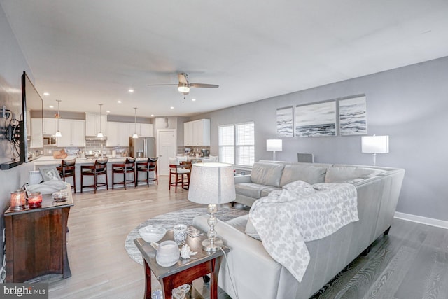 living room featuring light hardwood / wood-style floors and ceiling fan