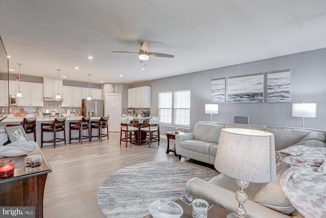 living room featuring light hardwood / wood-style floors and ceiling fan