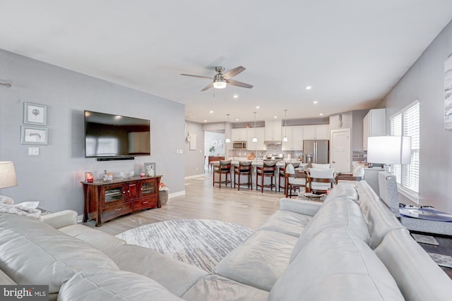 living room featuring ceiling fan and light wood-type flooring