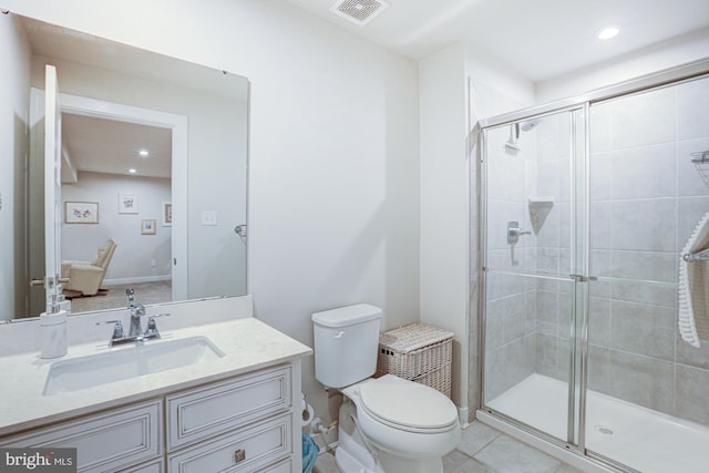 bathroom featuring vanity, a shower with shower door, tile patterned floors, and toilet