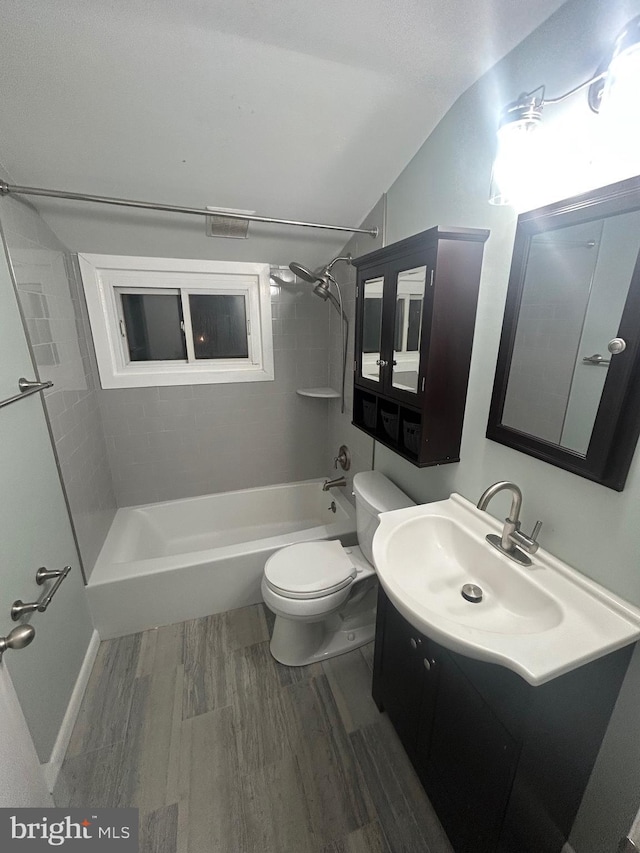 full bathroom with vanity, tiled shower / bath combo, wood-type flooring, and toilet