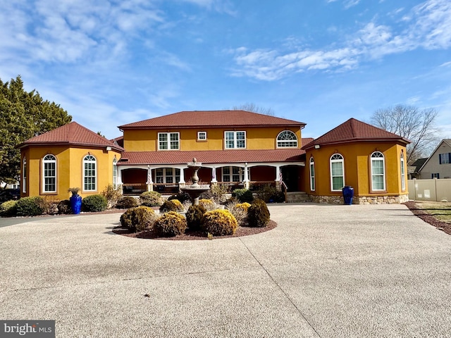 view of front of house featuring a tile roof, driveway, and stucco siding