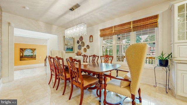 dining room with an inviting chandelier, light tile patterned flooring, and baseboards