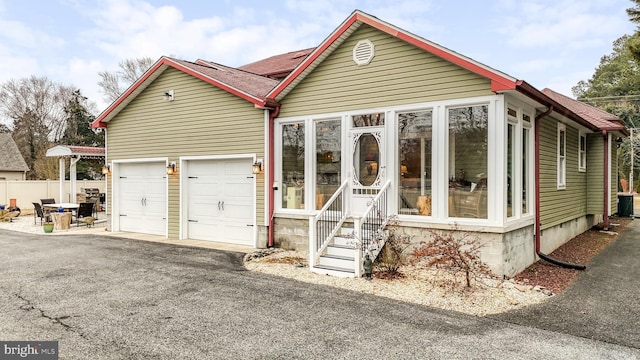 view of front of house featuring entry steps, driveway, an attached garage, and central AC unit
