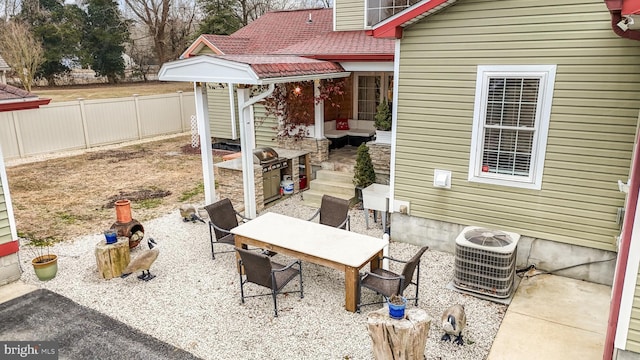 view of patio with fence, central AC unit, and outdoor dining space