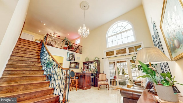 living room with recessed lighting, a high ceiling, stairway, a dry bar, and an inviting chandelier