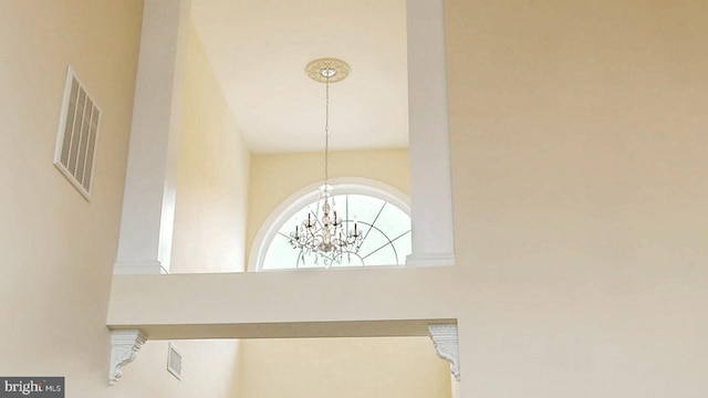 room details featuring visible vents and an inviting chandelier