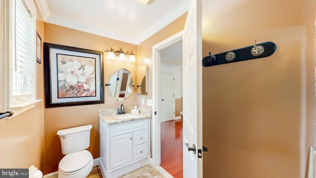 bathroom with baseboards, crown molding, vanity, and toilet