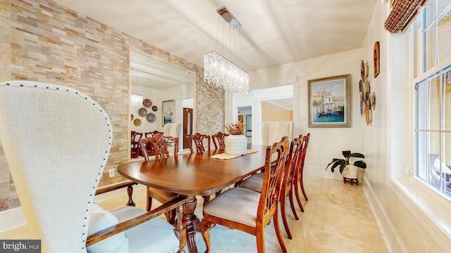 dining room with light tile patterned floors and an inviting chandelier