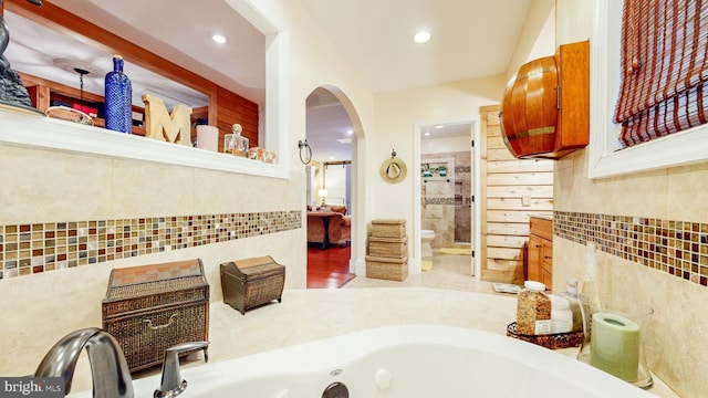 ensuite bathroom with recessed lighting, a whirlpool tub, connected bathroom, and toilet